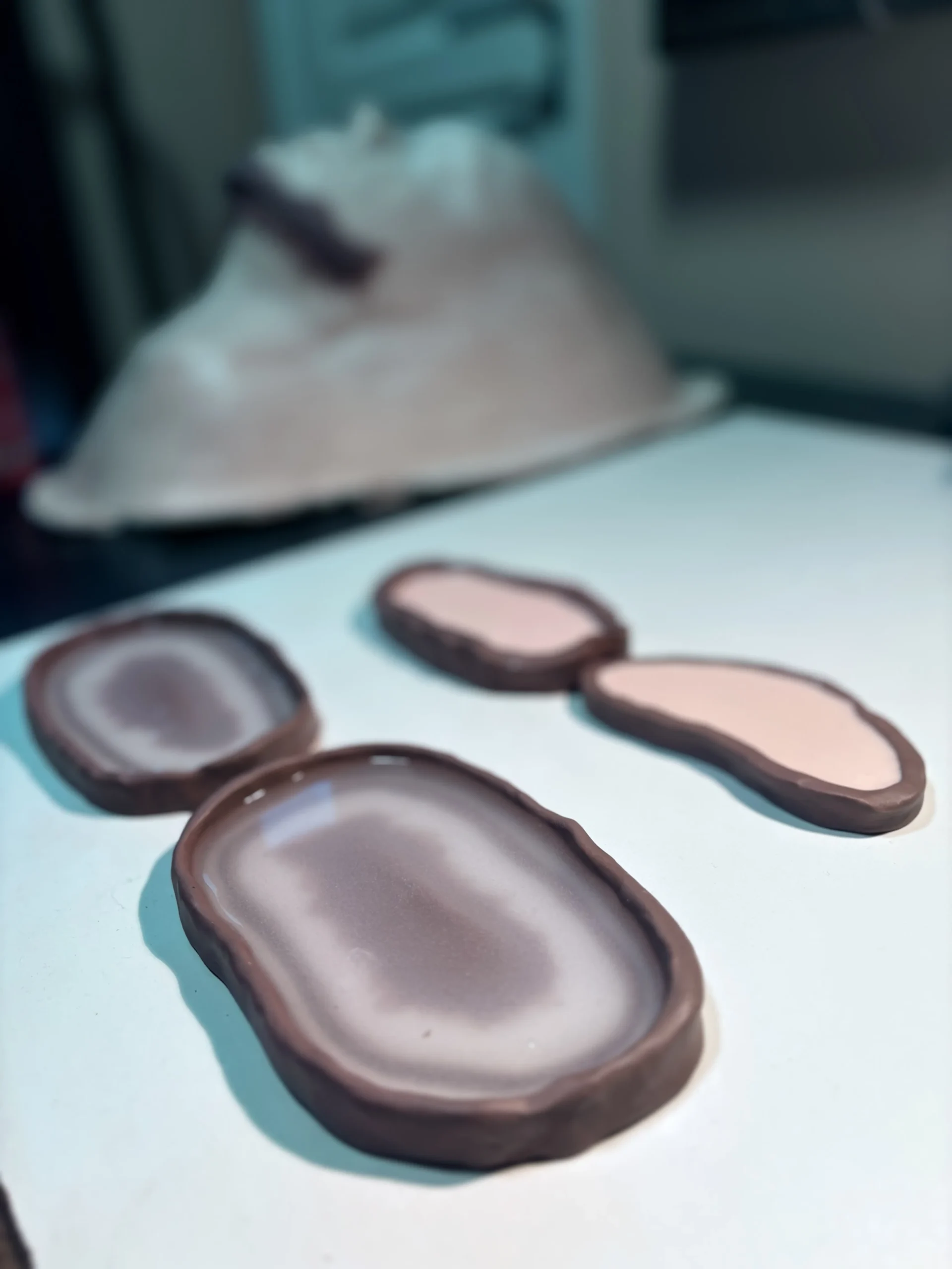 Petits moules de prothèses silicone en séchage sur le plan de travail, contre-moule en plâtre à l'arrière-plan