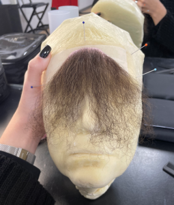 Photo d’un postiche de moustache en cours de réalisation en atelier