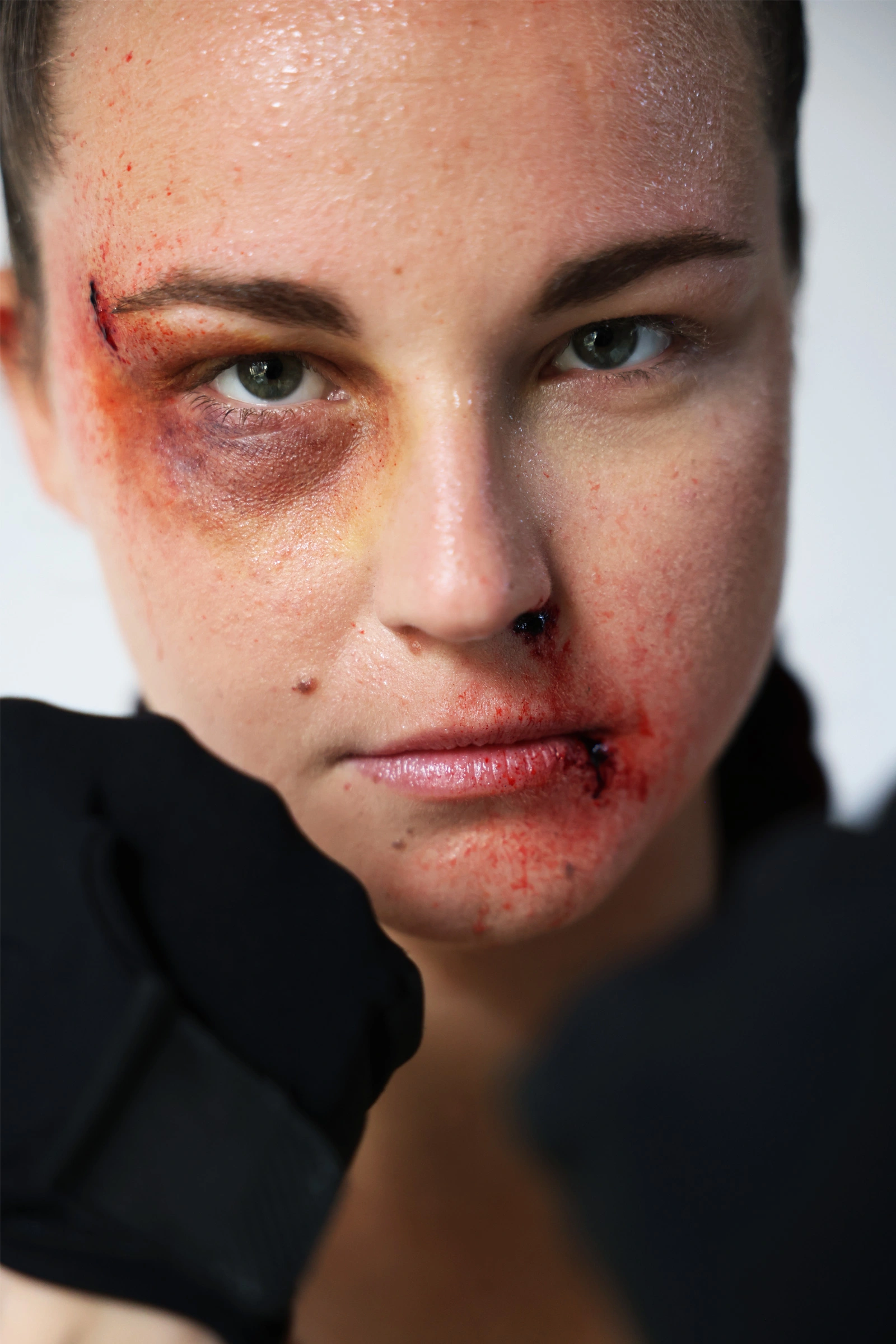 Maquillage d’effets spéciaux simulant des ecchymoses, coupures et gonflements sur le visage après coups